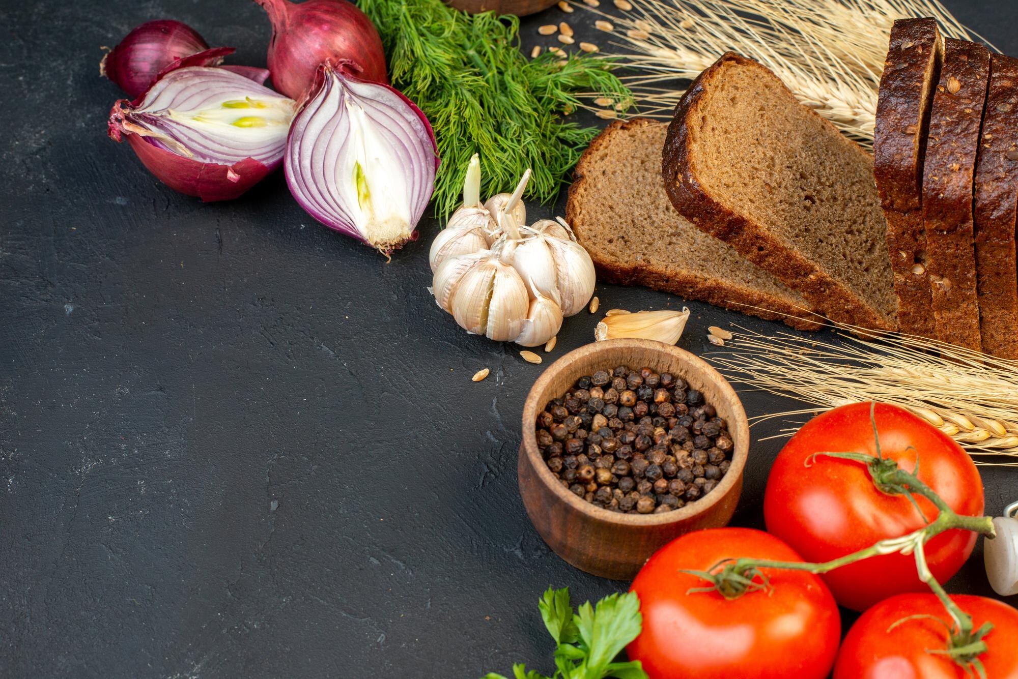Frisches Gemüse und Vollkornbrot auf einem Holztisch
